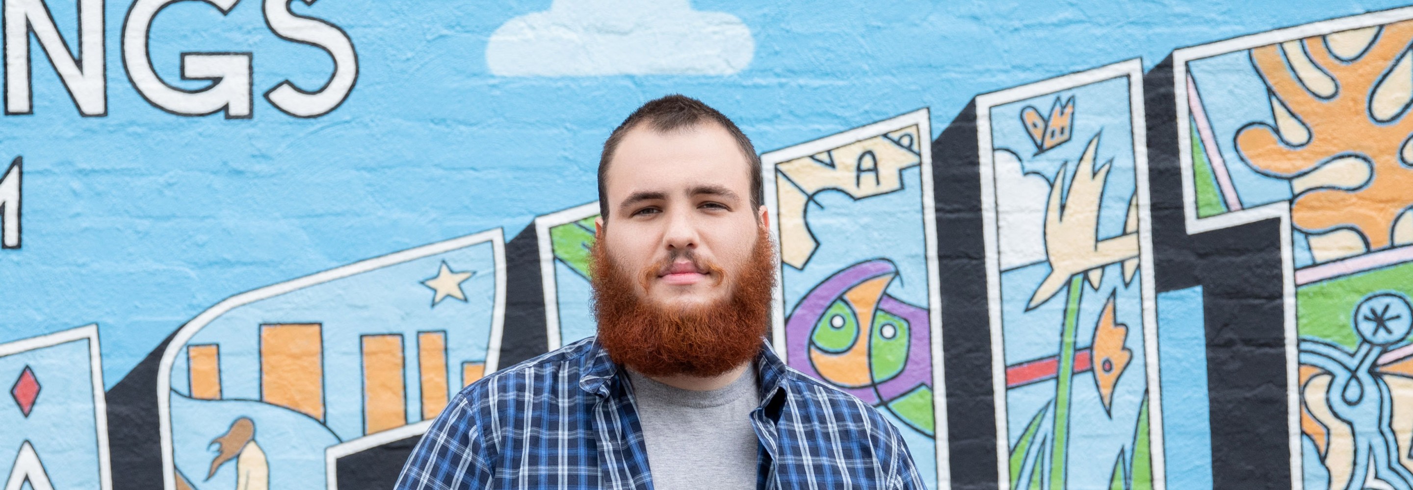 Tyler Williams portrait in front of a mural