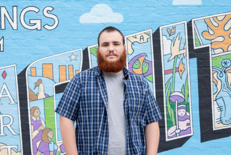 Tyler Williams portrait in front of a mural