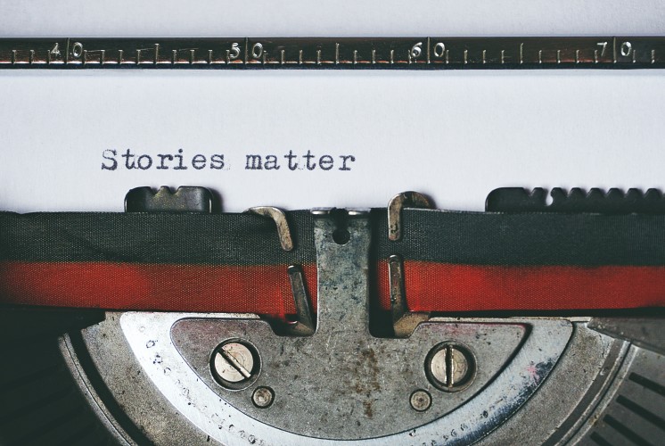 Text "stories matter" typed on white paper