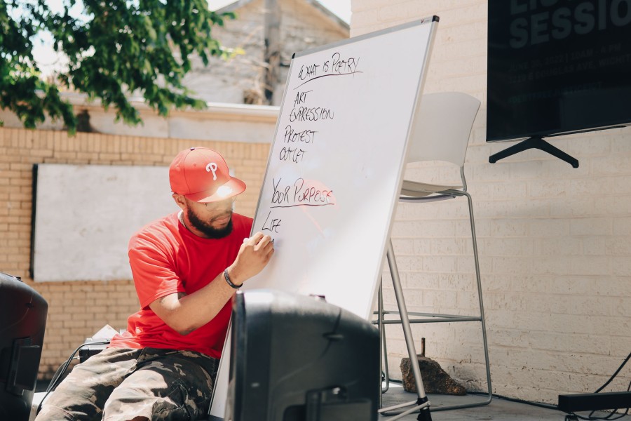 man writing on dry erase board